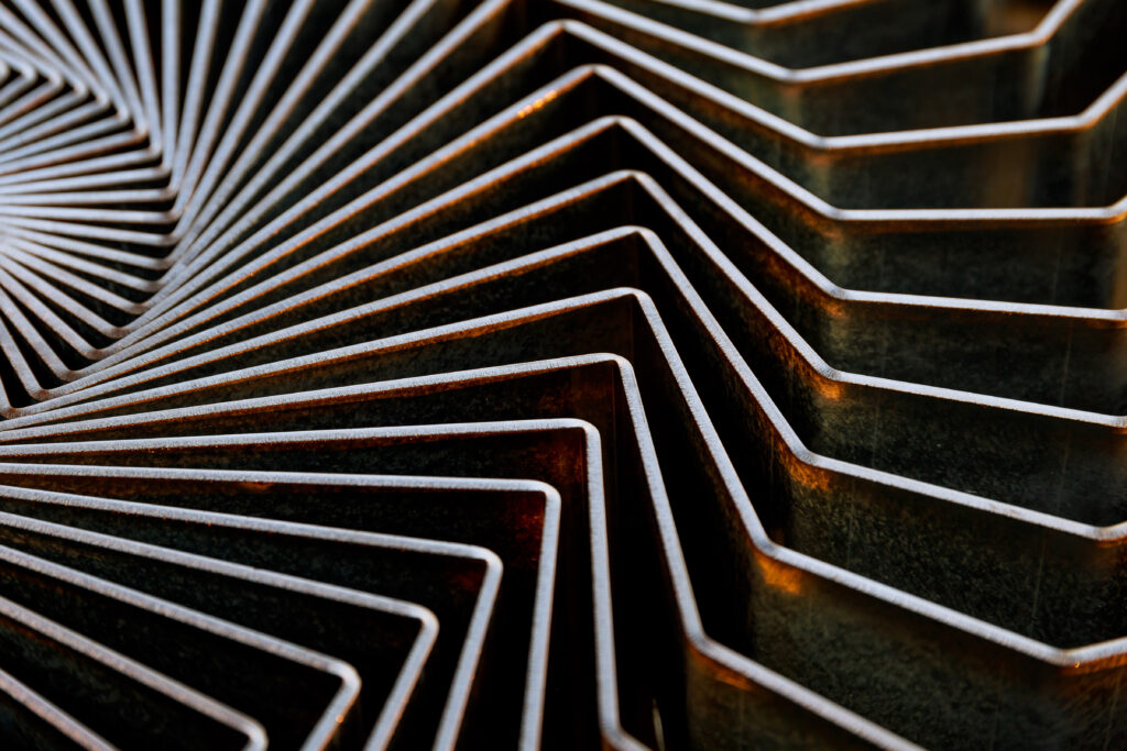 Close-up of stacked, laser-cut sheet metal parts with precise geometric edges.